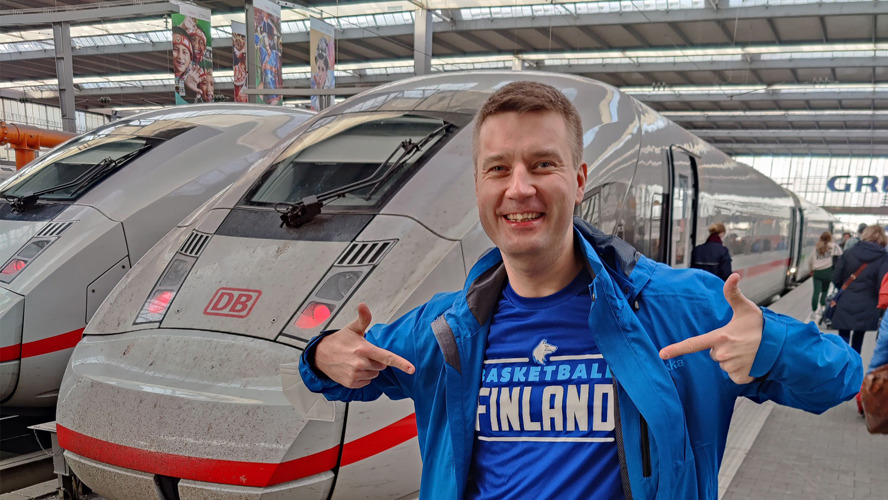 Integraatioasiantuntija Tuukka Heinänen seisoo hymyillen saksalaisella rautatieasemalla junan vieressä.